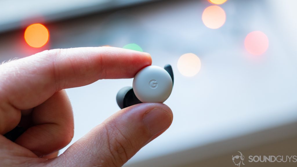The Google Pixel Buds 2020 true wireless earbuds held in between an index finger and thumb.