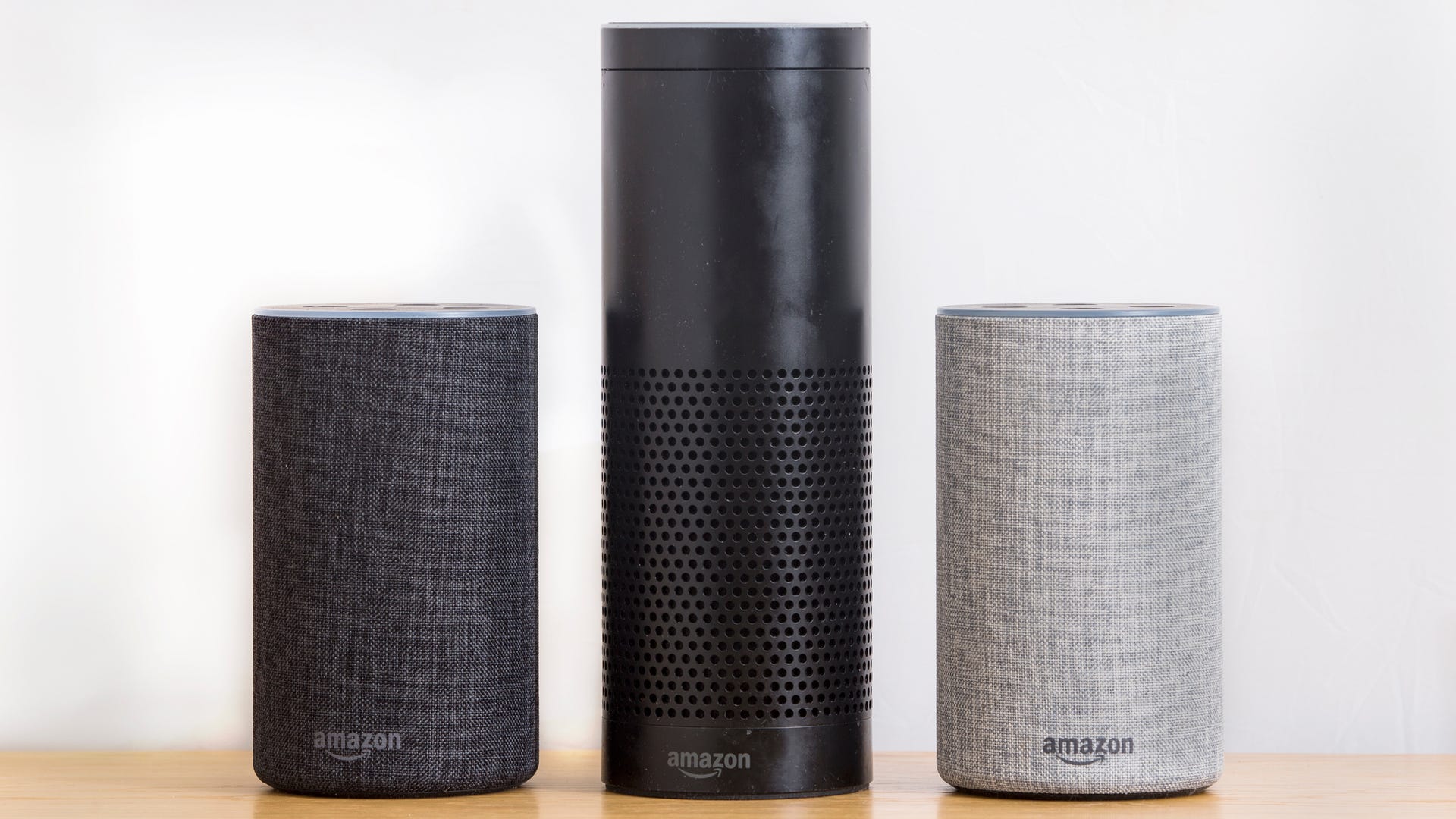 Amazon Echo Alexa Smart Speakers. 1st generation echo in the middle and 2nd generation speakers either side.