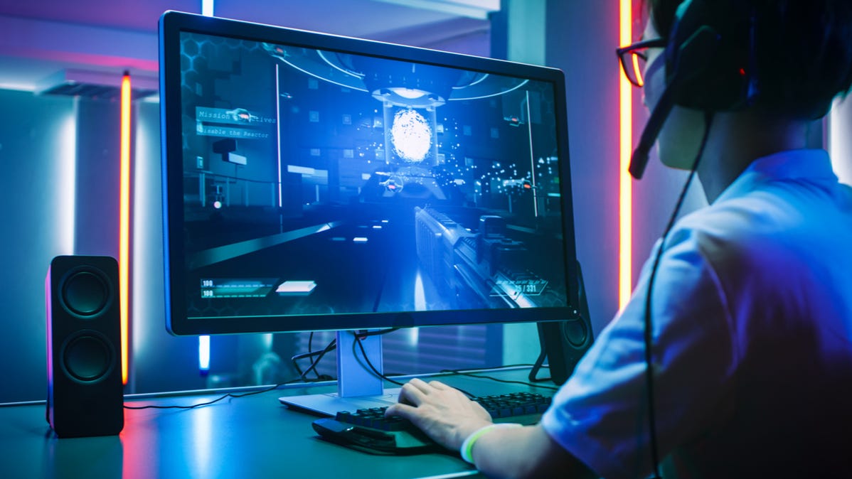 Back view of a professional gamer using a high-end PC monitor.