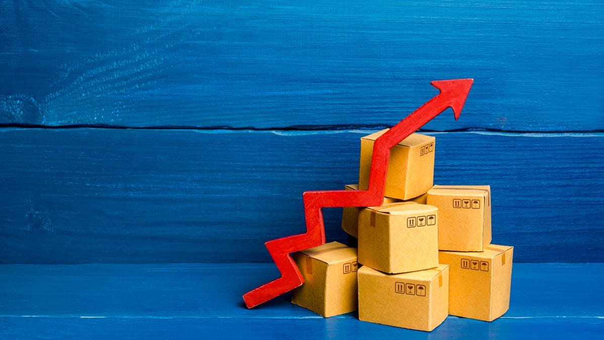 Red arrow rising over cardboard shipping boxes in a blue backdrop