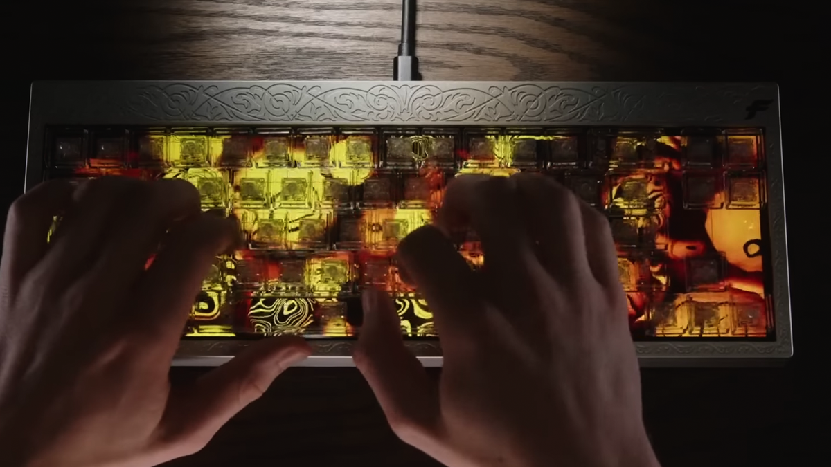 Someone typing on the Finalmouse Centerpiece keyboard as it shows a video of some blobby orange stuff.