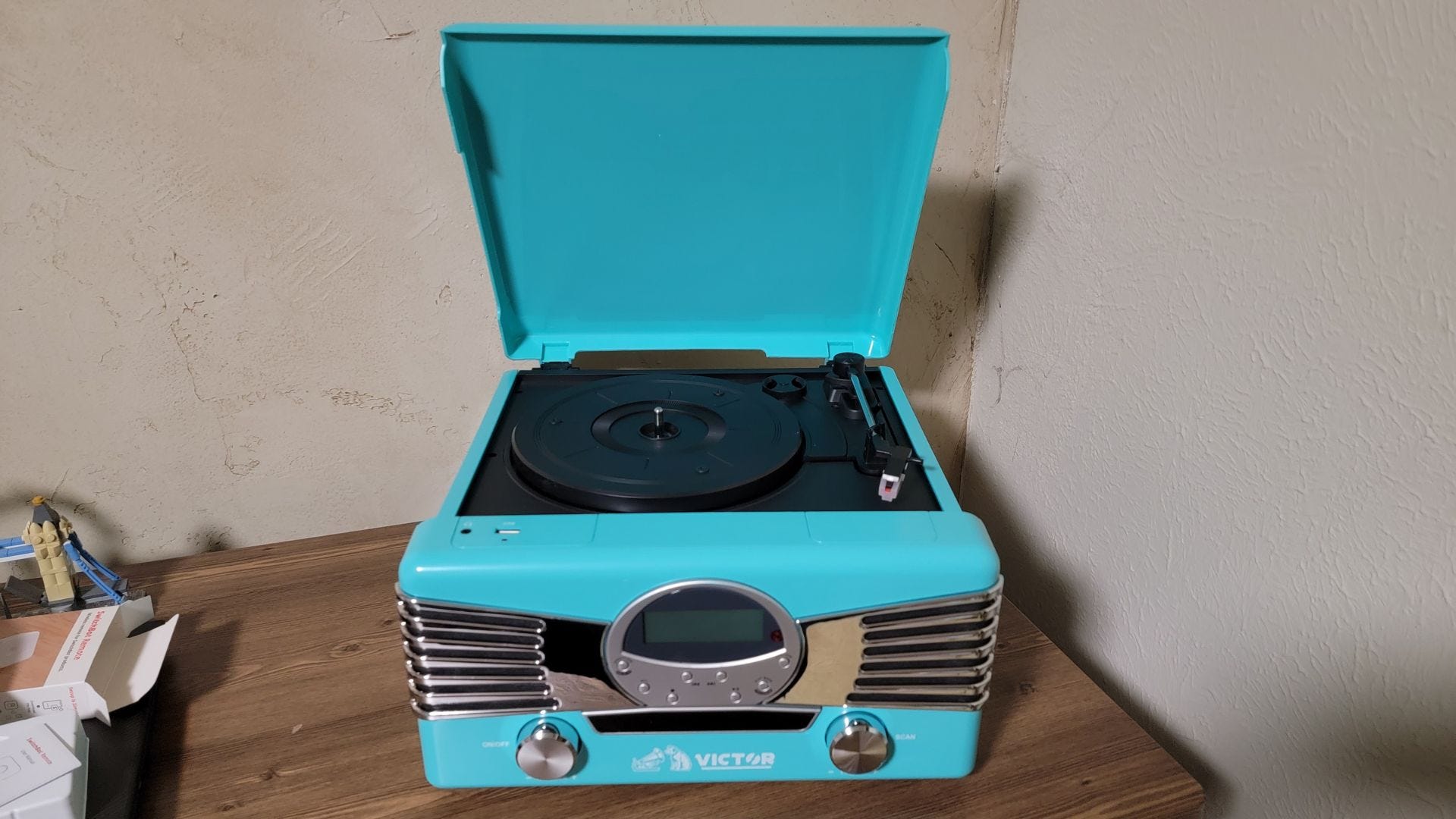 Turquoise Diner Record Player by Victor Audio sitting on desk with lifted lid