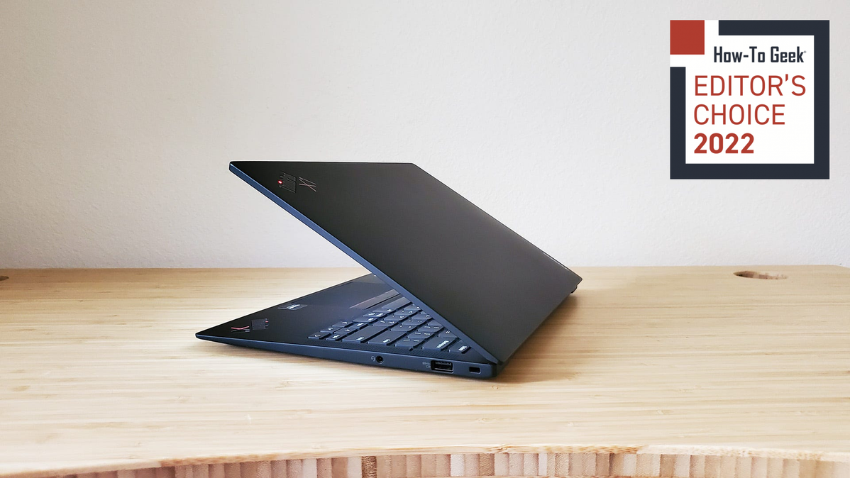 The Lenovo ThinkPad X1 Carbon laptop half open on a desk.