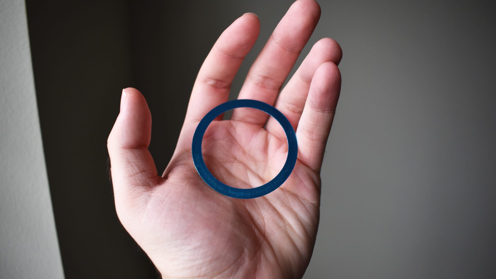 Person holding MagClap On-Go Power Bank magnetic ring in hand