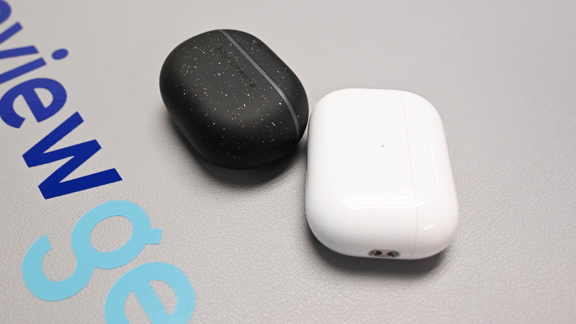 Soundpeats mini pro hs case next to airpods pro 2 case