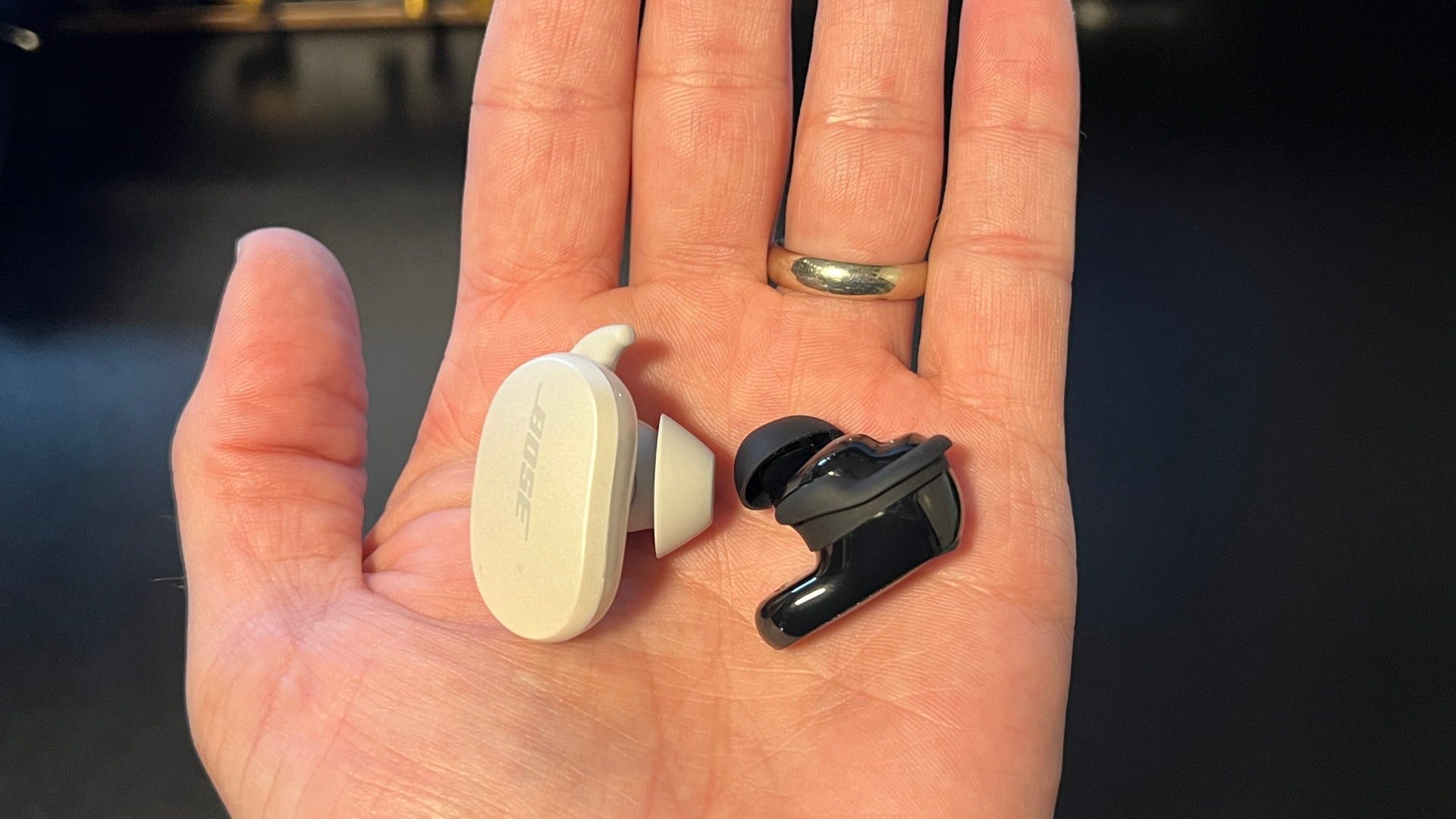 Bose QuietComfort 2 earbuds and original QuietComfort earbuds in hand for size comparison