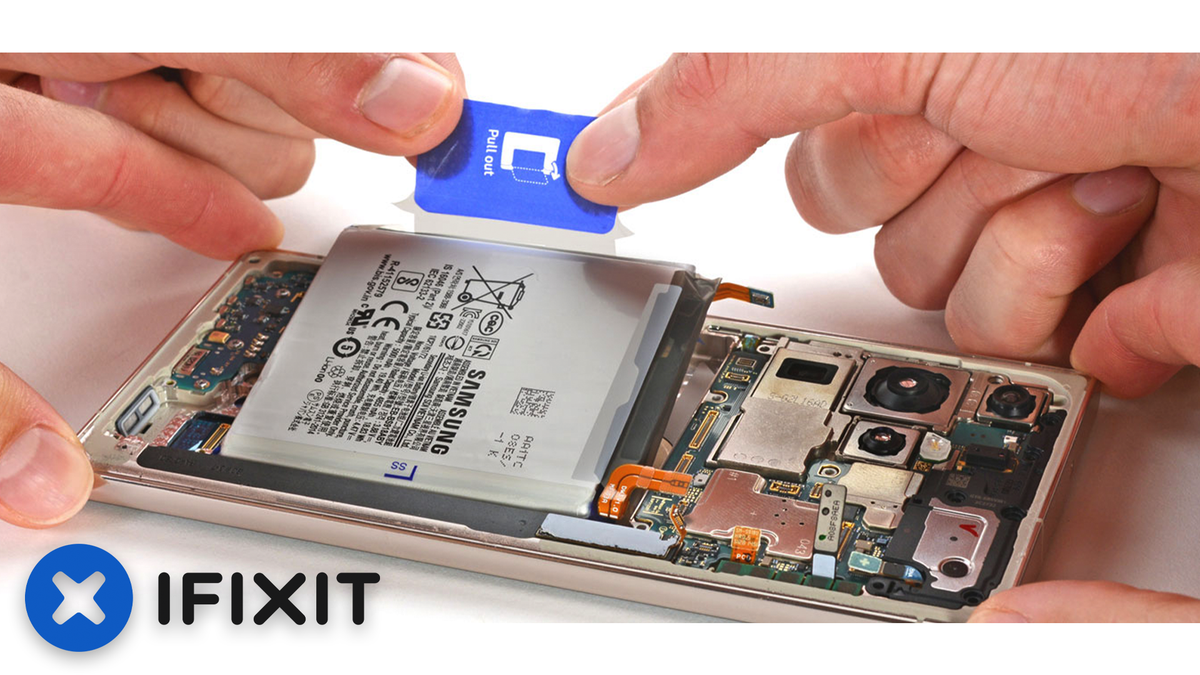 Employees at iFixit struggling to remove the battery from a Galaxy S23 Ultra.