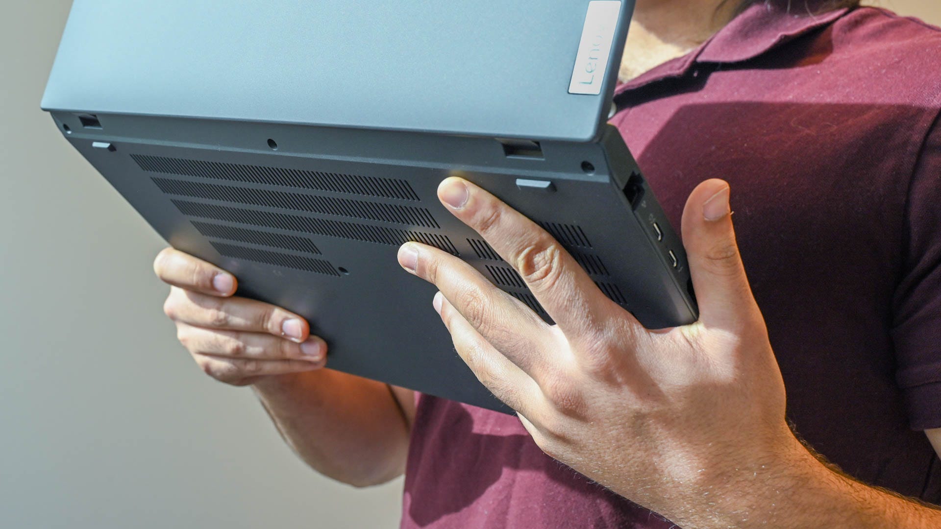 A person holding the Lenovo ThinkPad T16 Gen 1 to show the vents.