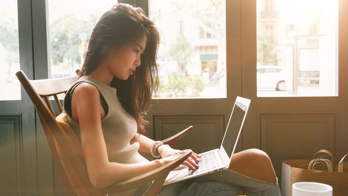 women using laptop in bright coffee shop