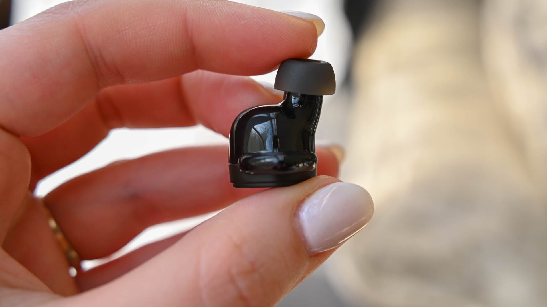 person-holding-an-audio-technica-ath-sq1tw-earbud-to-show-its-height-5122715