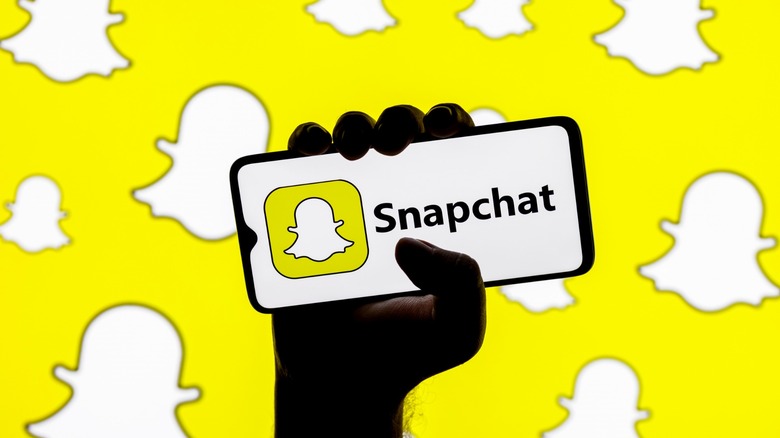 person holding a phone in their hand with a Snapchat logo