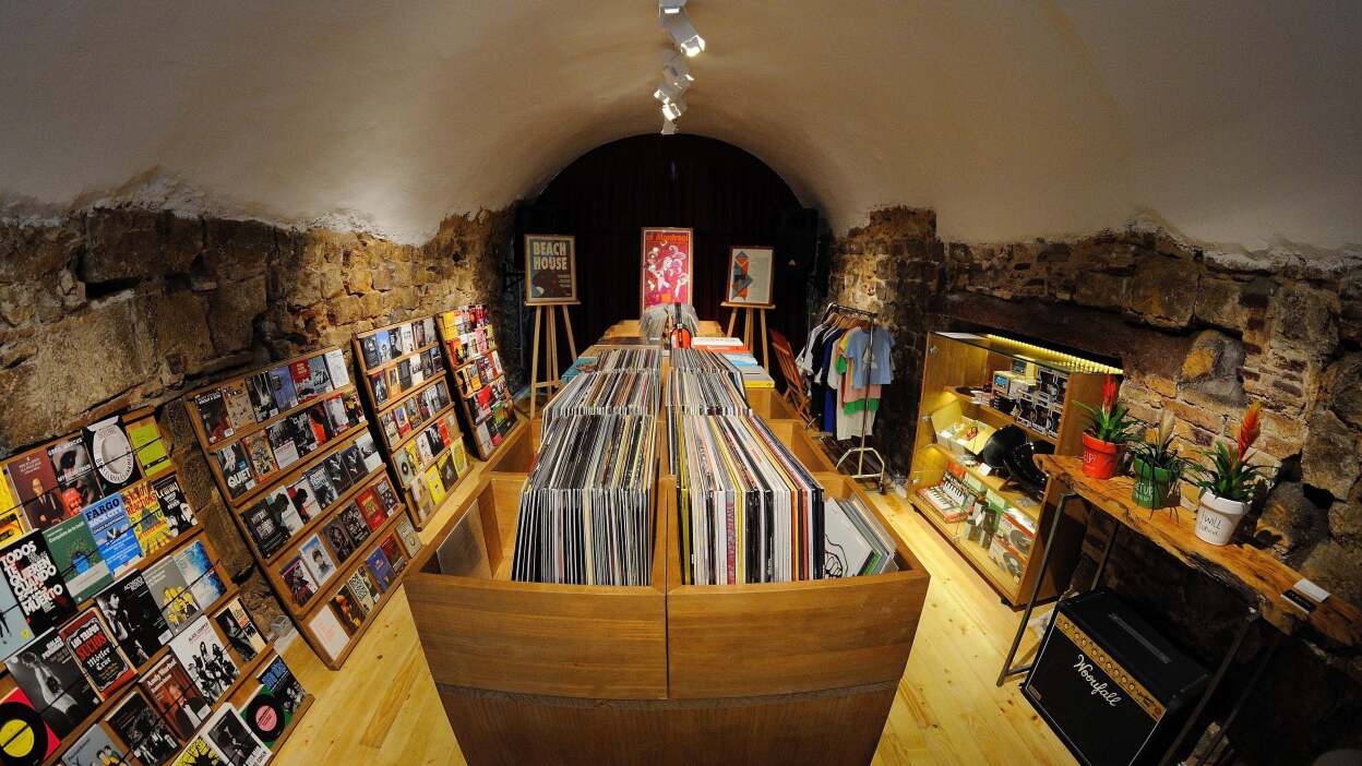 A photograph of record store shelves packed with vinyl albums
