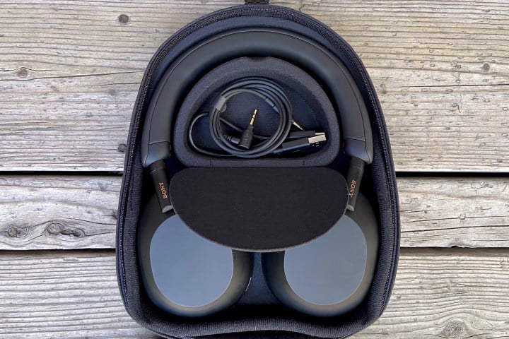 Sony WH-1000XM5 wireless headphones in travel case with accessories visible.